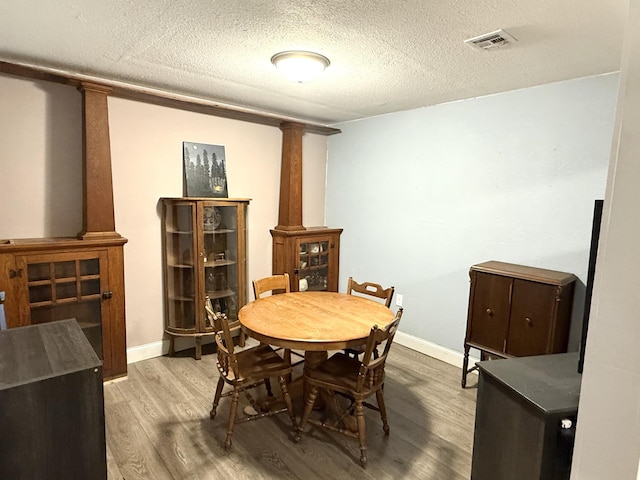 19421 708th Ave, Dassel, MN 55325 - dining space featuring decorative columns, wood finished floors, and a textured ceiling