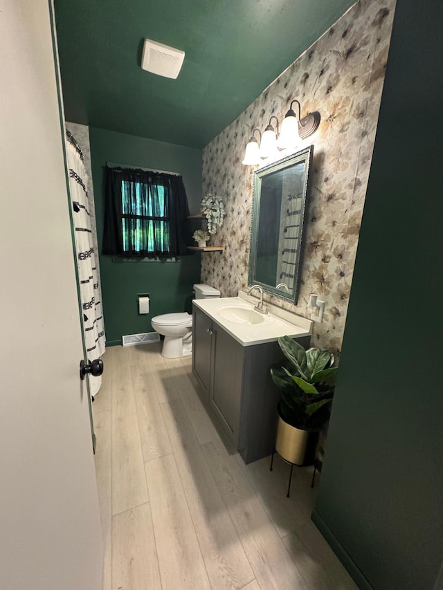 815 6th St N, New Ulm, MN 56073 - bathroom with wallpapered walls, wood finished floors, and vanity
