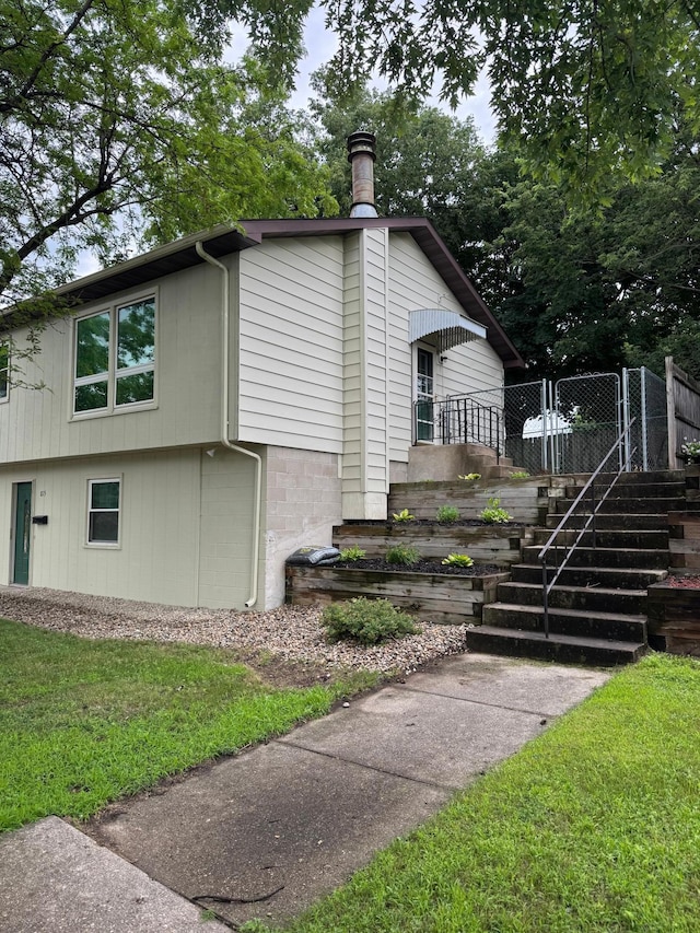 815 6th St N, New Ulm, MN 56073 - view of side of home with stairs and a lawn