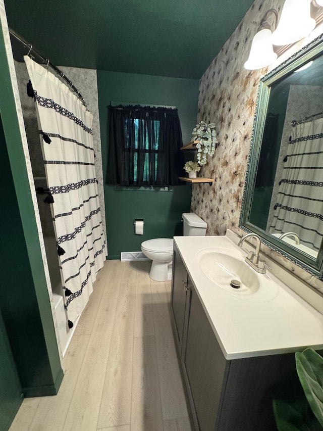 815 6th St N, New Ulm, MN 56073 - bathroom with vanity, wood finished floors, shower / bath combination with curtain, and wallpapered walls