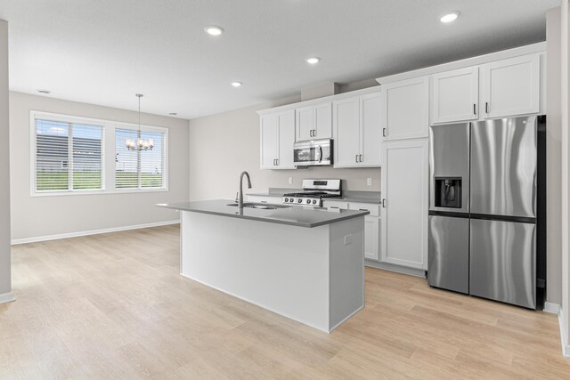 10070 32nd St NE, Saint Michael, MN 55376 - kitchen featuring stainless steel appliances, light wood finished floors, a chandelier, white cabinets, and a center island with sink