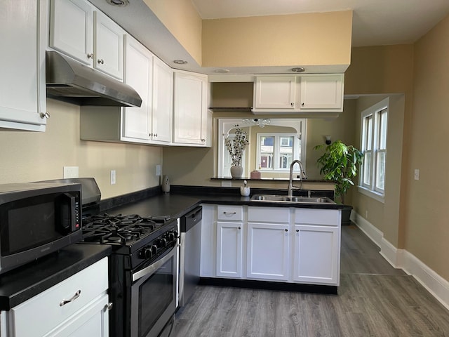 482 Edmund Ave, Saint Paul, MN 55103 - kitchen featuring stainless steel appliances, under cabinet range hood, white cabinets, and dark countertops