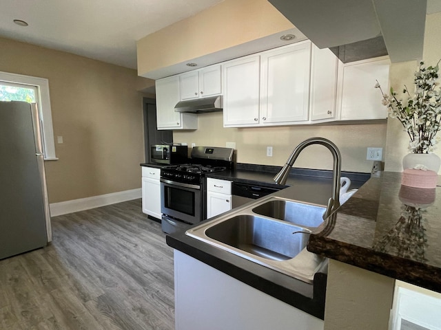 482 Edmund Ave, Saint Paul, MN 55103 - kitchen featuring stainless steel appliances, white cabinets, dark countertops, and under cabinet range hood