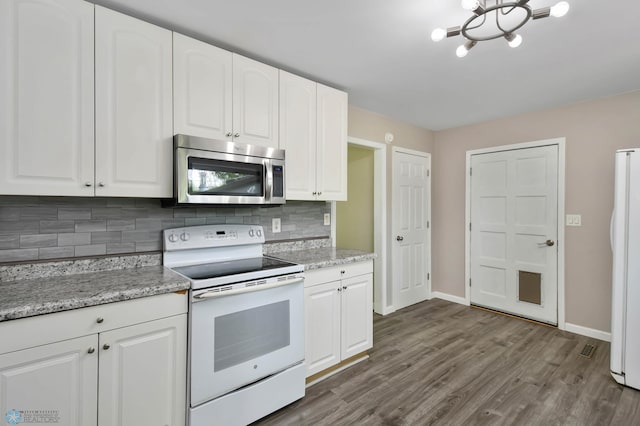 219 10th Ave E, Fargo, ND 58078 - kitchen with white appliances, tasteful backsplash, dark wood finished floors, and white cabinetry