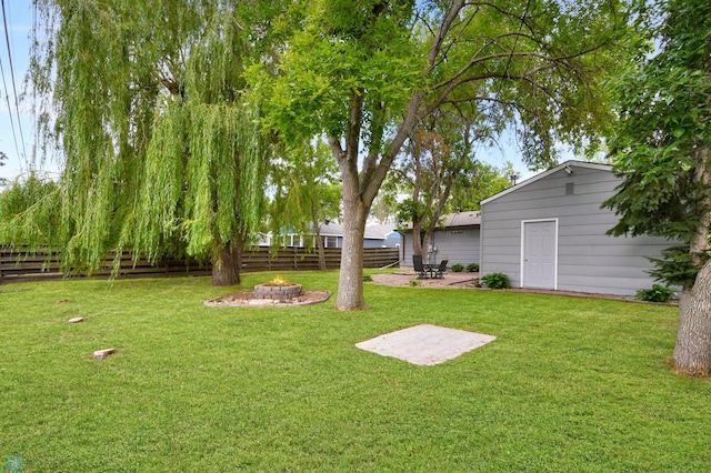 219 10th Ave E, Fargo, ND 58078 - fenced backyard featuring a fire pit and a patio
