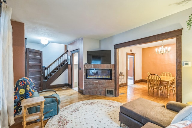 3331 34th Ave S, Minneapolis, MN 55406 - living room featuring wood finished floors, a chandelier, and a glass covered fireplace