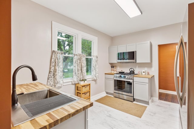 3331 34th Ave S, Minneapolis, MN 55406 - kitchen with appliances with stainless steel finishes, wooden counters, light marble finish flooring, and a desk