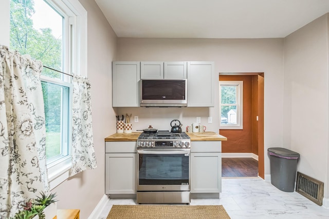 3331 34th Ave S, Minneapolis, MN 55406 - kitchen featuring appliances with stainless steel finishes, wood counters, light marble finish floors, and gray cabinets