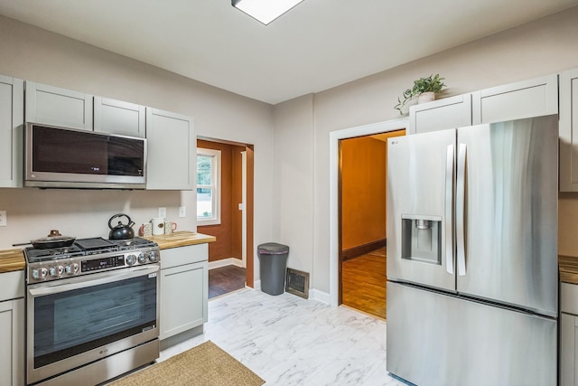 3331 34th Ave S, Minneapolis, MN 55406 - kitchen featuring stainless steel appliances, light marble finish flooring, and wood counters