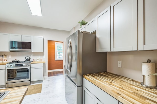 3331 34th Ave S, Minneapolis, MN 55406 - kitchen with appliances with stainless steel finishes, wooden counters, and light marble finish flooring