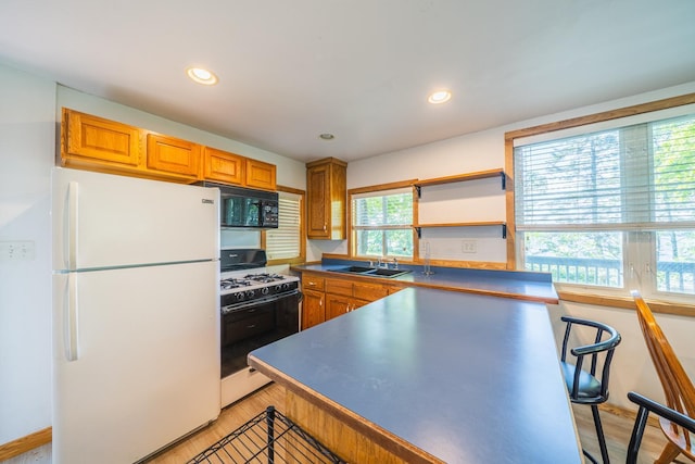 23546 Warbler Way Unit C1, Detroit Lakes, MN 56501 - kitchen with freestanding refrigerator, range with gas stovetop, black microwave, light wood-style flooring, and a breakfast bar area