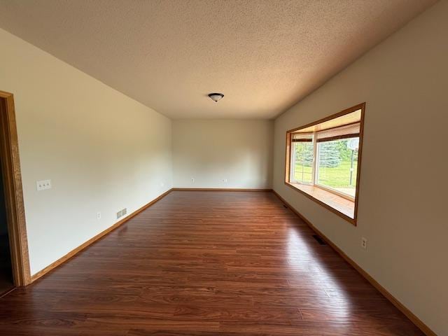 1355 Butterfly Ln, Spring Lake Twp, MN 55352 - empty room featuring dark wood-type flooring and a textured ceiling
