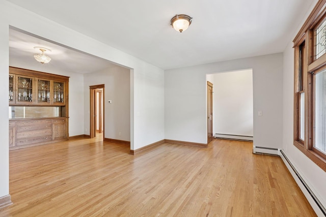 704-706 Holly Ave, Saint Paul, MN 55104 - unfurnished room featuring a baseboard radiator and light wood-style floors