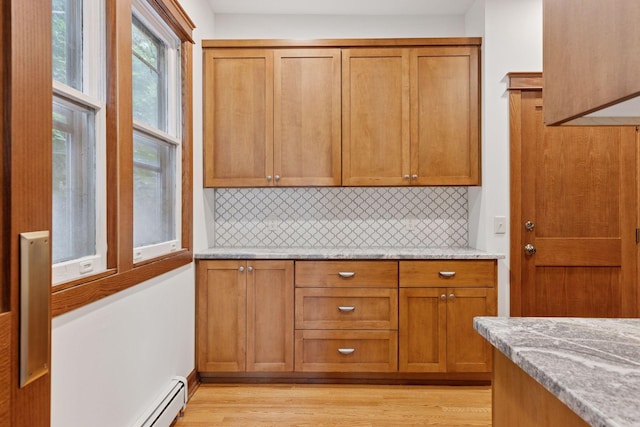 704-706 Holly Ave, Saint Paul, MN 55104 - kitchen featuring decorative backsplash, brown cabinetry, light wood-type flooring, and a baseboard radiator
