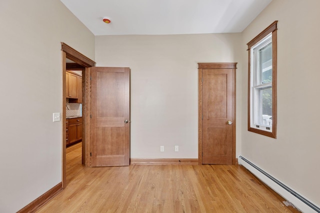 704-706 Holly Ave, Saint Paul, MN 55104 - unfurnished bedroom with baseboard heating and light wood finished floors