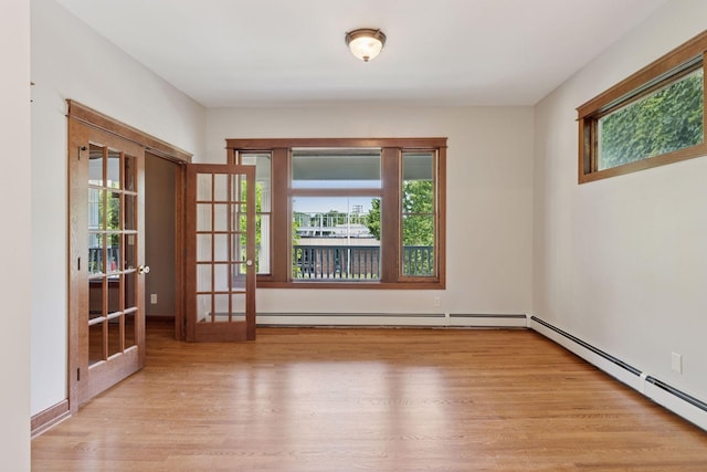 704-706 Holly Ave, Saint Paul, MN 55104 - spare room featuring healthy amount of natural light, wood finished floors, and a baseboard radiator