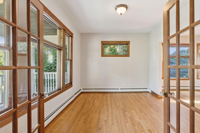 704-706 Holly Ave, Saint Paul, MN 55104 - empty room featuring a baseboard radiator, light wood finished floors, and french doors