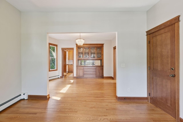 704-706 Holly Ave, Saint Paul, MN 55104 - unfurnished dining area featuring a baseboard heating unit, light wood finished floors, and a chandelier