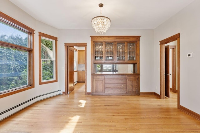 704-706 Holly Ave, Saint Paul, MN 55104 - unfurnished dining area with a baseboard radiator, a chandelier, and light wood finished floors