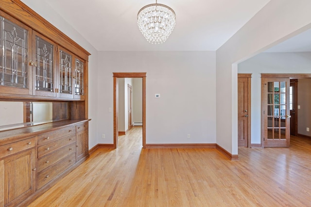 704-706 Holly Ave, Saint Paul, MN 55104 - unfurnished dining area featuring light wood finished floors, a baseboard radiator, and a chandelier