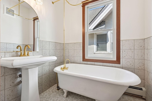 704-706 Holly Ave, Saint Paul, MN 55104 - full bathroom with tile walls, baseboard heating, a freestanding bath, a wainscoted wall, and tile patterned floors