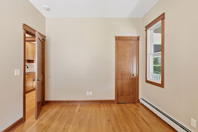 704-706 Holly Ave, Saint Paul, MN 55104 - empty room with a baseboard radiator, light wood finished floors, and a smoke detector