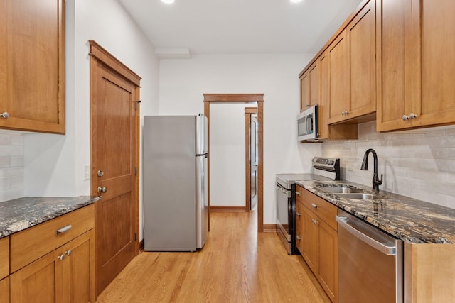 704-706 Holly Ave, Saint Paul, MN 55104 - kitchen with stainless steel appliances, light wood-style floors, tasteful backsplash, dark stone countertops, and recessed lighting