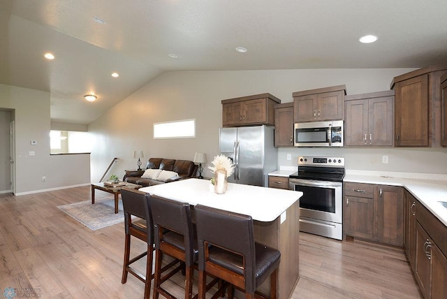 8037 Goldfinch Dr, Horace, ND 58047 - kitchen with stainless steel appliances, vaulted ceiling, light countertops, light wood-style flooring, and open floor plan