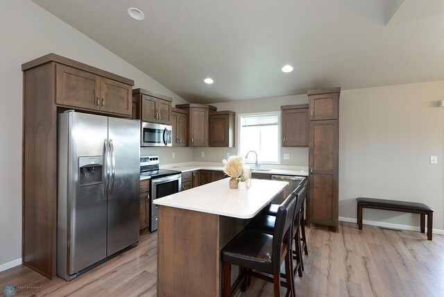 8037 Goldfinch Dr, Horace, ND 58047 - kitchen with appliances with stainless steel finishes, light wood-style flooring, a center island, light countertops, and lofted ceiling