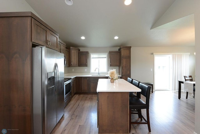8037 Goldfinch Dr, Horace, ND 58047 - kitchen with stainless steel appliances, a kitchen island, a kitchen breakfast bar, light wood-type flooring, and recessed lighting