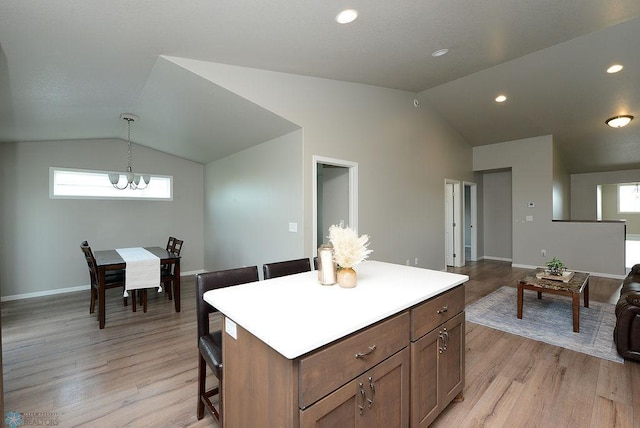 8037 Goldfinch Dr, Horace, ND 58047 - kitchen featuring vaulted ceiling, a chandelier, light wood finished floors, decorative light fixtures, and light countertops
