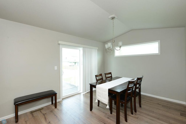 8037 Goldfinch Dr, Horace, ND 58047 - dining space featuring a chandelier, wood finished floors, plenty of natural light, and vaulted ceiling