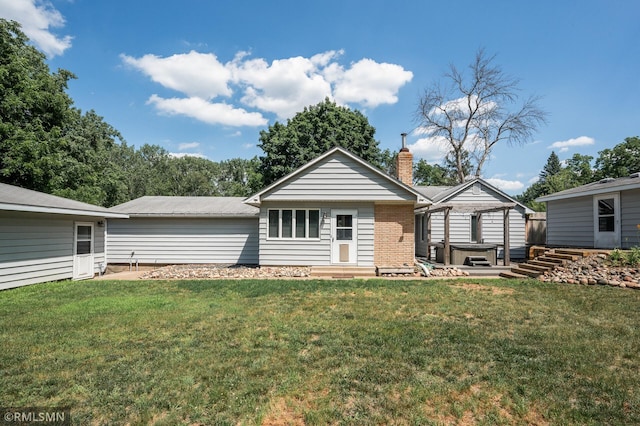 3308 Chippewa Rd, Minnetonka, MN 55305 - rear view of house featuring a hot tub, a lawn, a chimney, and brick siding