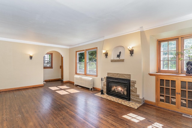 4340 Oakland Ave, Minneapolis, MN 55407 - unfurnished living room with radiator heating unit, crown molding, a fireplace with flush hearth, wood finished floors, and arched walkways