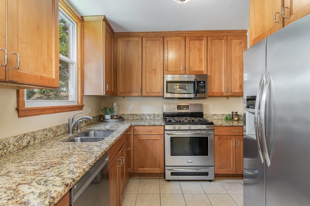 4340 Oakland Ave, Minneapolis, MN 55407 - kitchen with stainless steel appliances, brown cabinets, light tile patterned flooring, and light stone counters