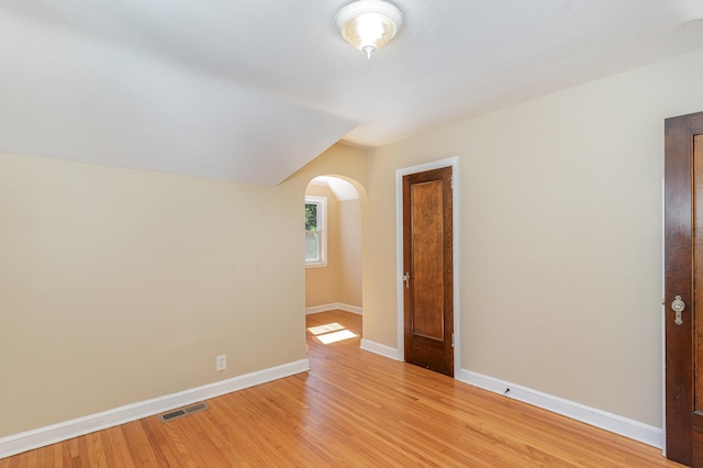4340 Oakland Ave, Minneapolis, MN 55407 - empty room with arched walkways, vaulted ceiling, and light wood finished floors