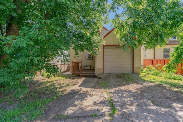 4340 Oakland Ave, Minneapolis, MN 55407 - view of property hidden behind natural elements with stucco siding, driveway, and a garage
