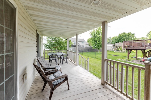 1404 8th St NW, Kasson, MN 55944 - wooden terrace with a playground, outdoor dining space, and a fenced backyard