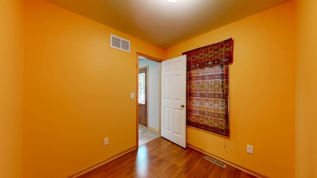 1404 8th St NW, Kasson, MN 55944 - spare room featuring wood finished floors and a textured ceiling