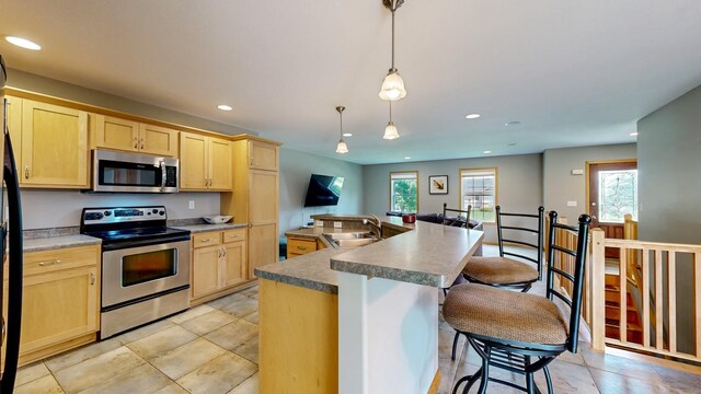 1404 8th St NW, Kasson, MN 55944 - kitchen with stainless steel appliances, light brown cabinetry, recessed lighting, healthy amount of natural light, and an island with sink