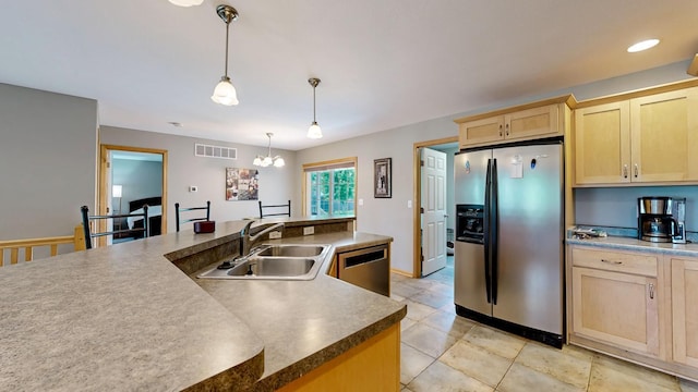 1404 8th St NW, Kasson, MN 55944 - kitchen featuring appliances with stainless steel finishes, light brown cabinets, light tile patterned flooring, hanging light fixtures, and a chandelier
