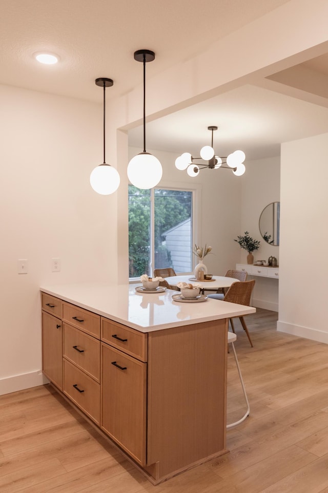212 Diamond Lake Rd, Minneapolis, MN 55419 - kitchen with a peninsula, light countertops, light wood-type flooring, and hanging light fixtures