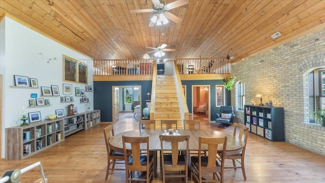 8825 Greeley Loop, Royalton Twp, MN 55006 - dining area with brick wall, wooden ceiling, a ceiling fan, wood finished floors, and stairway