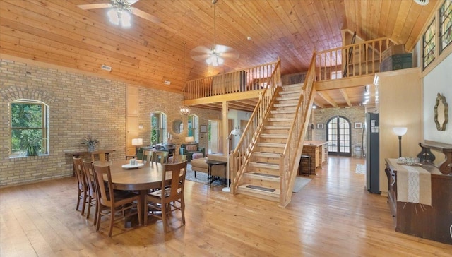 8825 Greeley Loop, Royalton Twp, MN 55006 - dining room with high vaulted ceiling, brick wall, ceiling fan, stairs, and light wood-style flooring