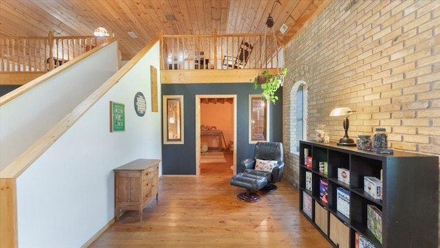 8825 Greeley Loop, Royalton Twp, MN 55006 - living area featuring wooden ceiling, brick wall, wood-type flooring, and high vaulted ceiling