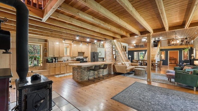 8825 Greeley Loop, Royalton Twp, MN 55006 - living room with a wood stove, a wood ceiling with exposed beams, and light wood-style floors