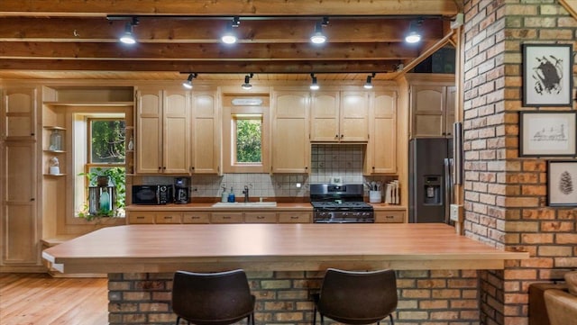 8825 Greeley Loop, Royalton Twp, MN 55006 - kitchen featuring stainless steel range with gas stovetop, fridge with ice dispenser, rail lighting, light wood finished floors, and a kitchen breakfast bar