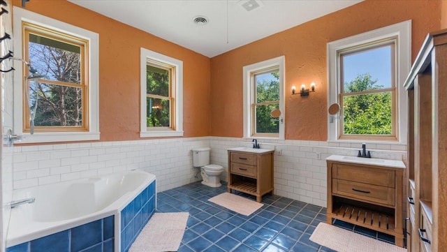 8825 Greeley Loop, Royalton Twp, MN 55006 - full bath featuring vanity, tile patterned floors, tile walls, a garden tub, and a wainscoted wall