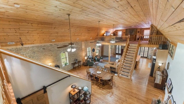8825 Greeley Loop, Royalton Twp, MN 55006 - living area featuring wood walls, wood finished floors, wooden ceiling, ceiling fan, and stairs
