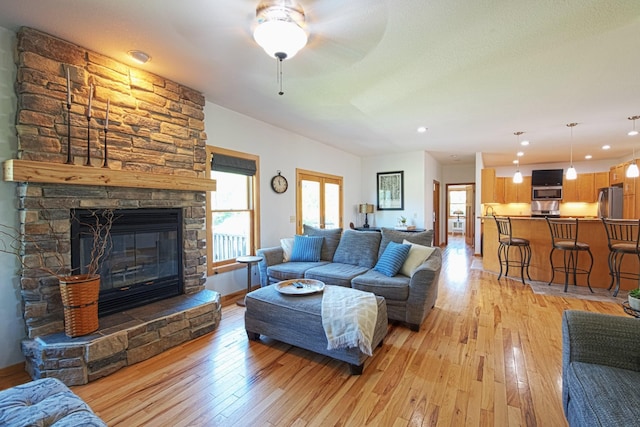 10199 330th St W, Northfield, MN 55057 - living area with light wood finished floors, a stone fireplace, recessed lighting, and a ceiling fan